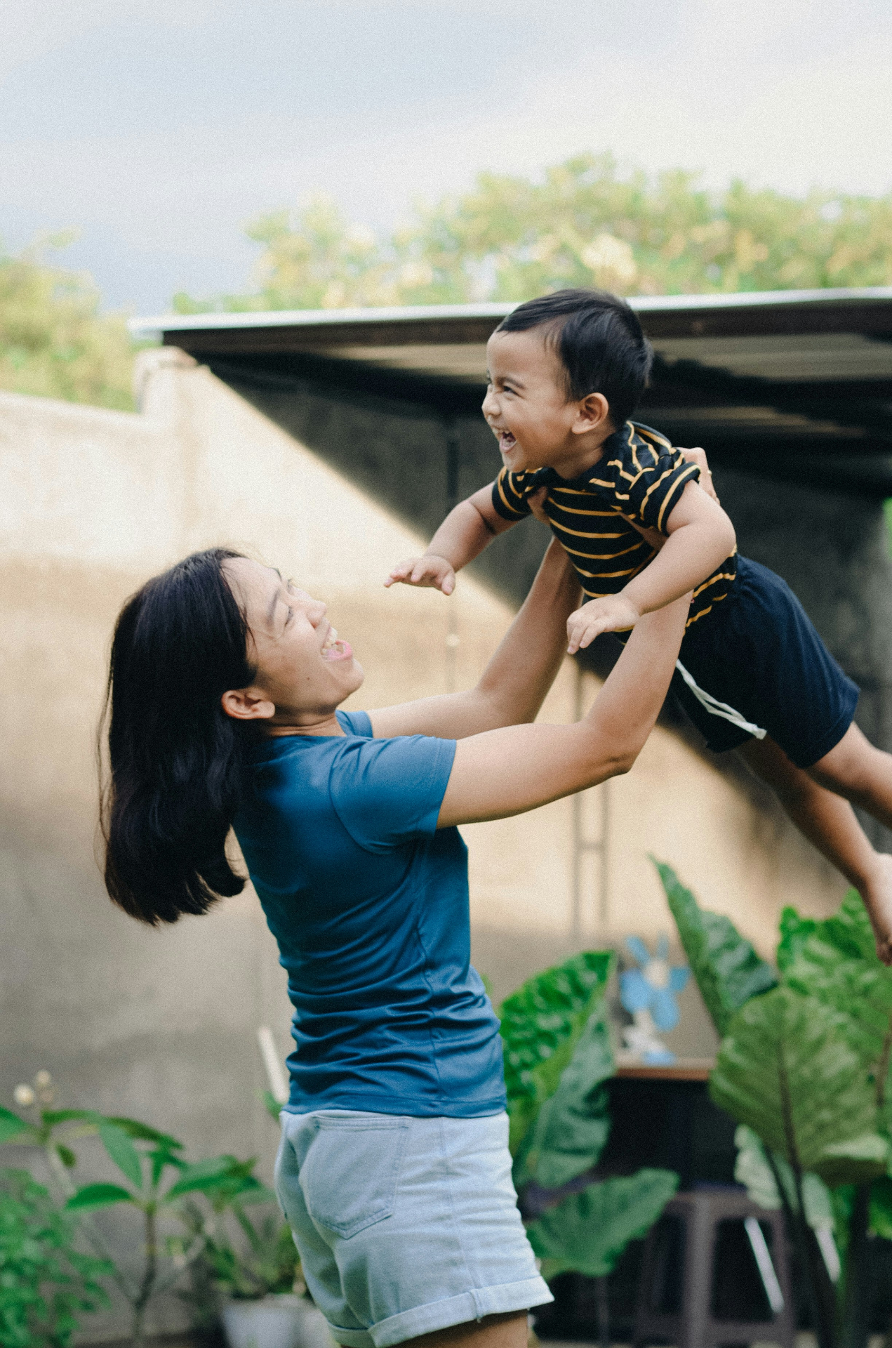 Caring Filipino nanny reading to a child in a warm family home